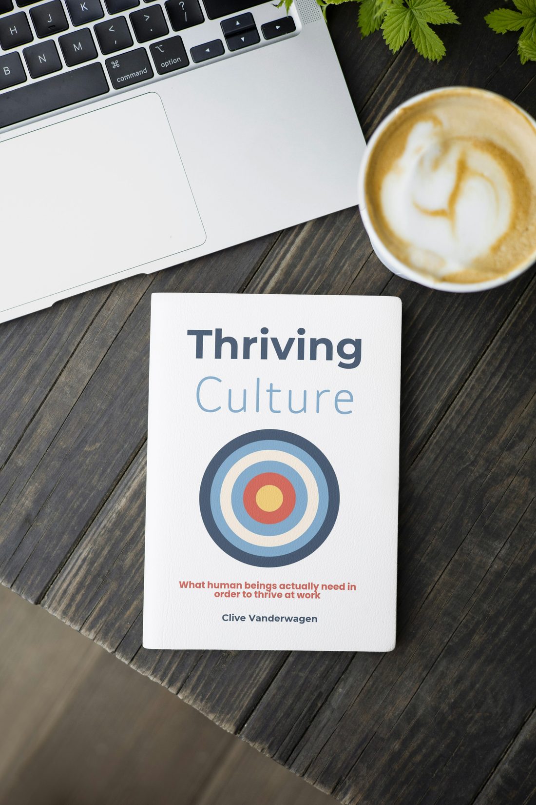 Thriving Culture on a desk beside a laptop and coffee
